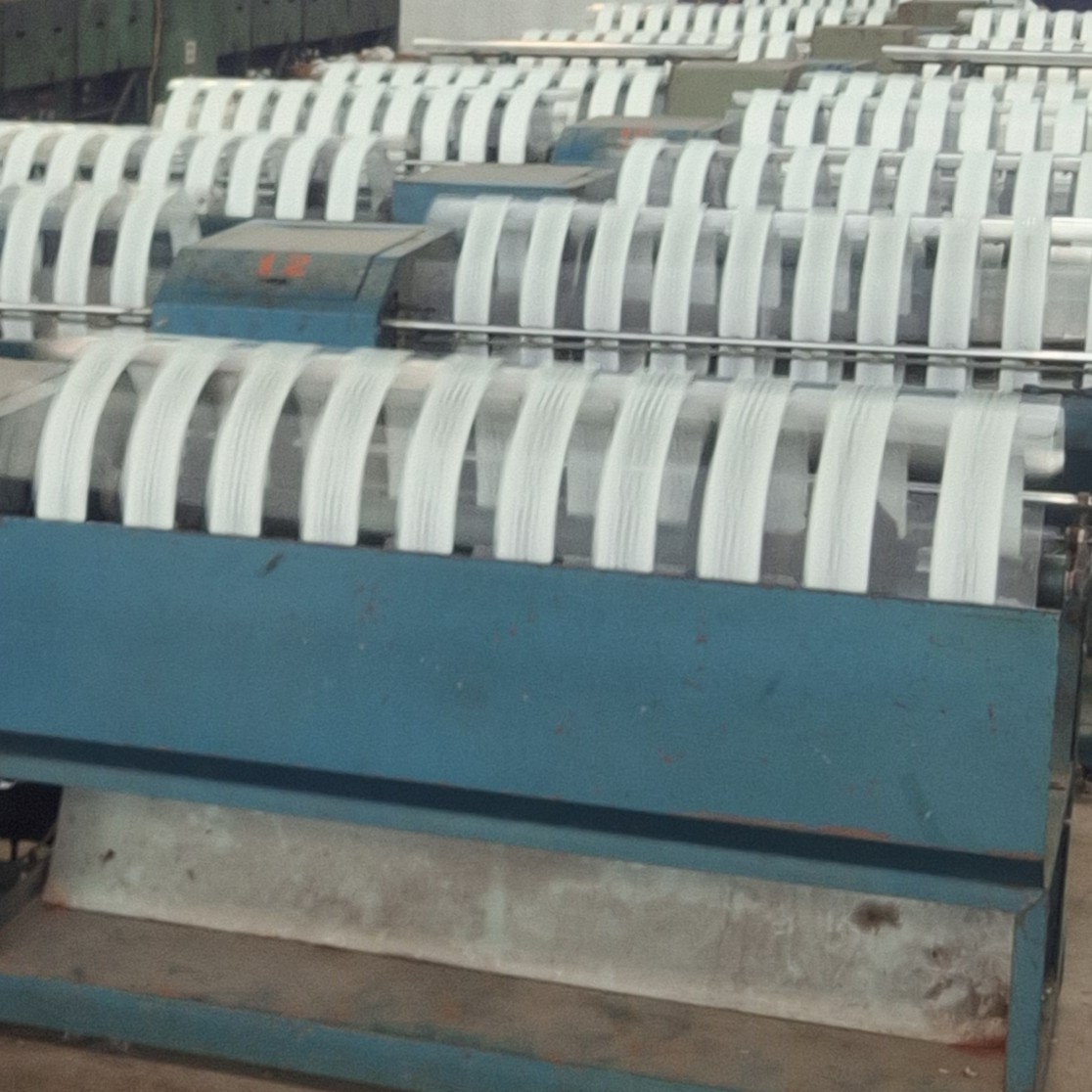 Mesin penggulung benang otomatis yang menggulung ulang benang berwarna dengan efisiensi tinggi, melengkapi proses produksi di CV Yuvin Abadi Jaya.